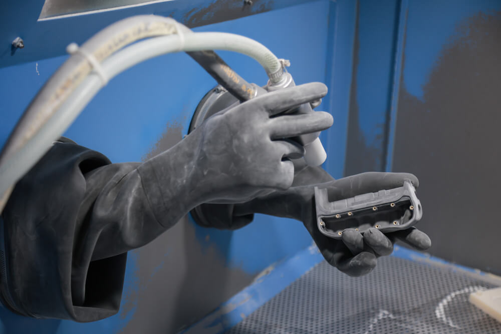 Close-up of abrasive blasting a prototype housing