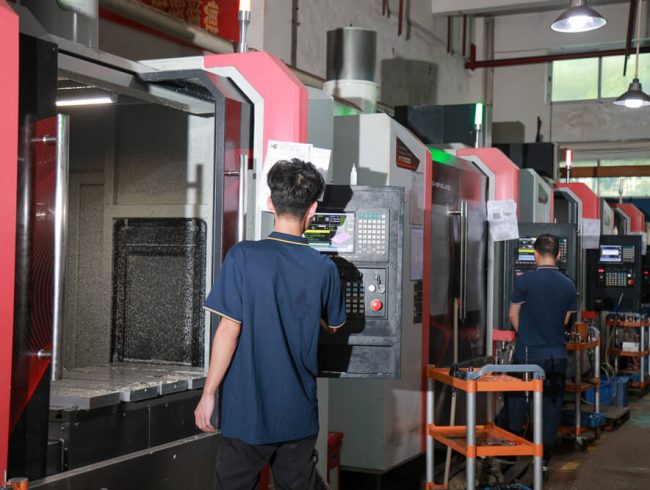 CNC operator reviewing a part against the controlled drawing at the machine