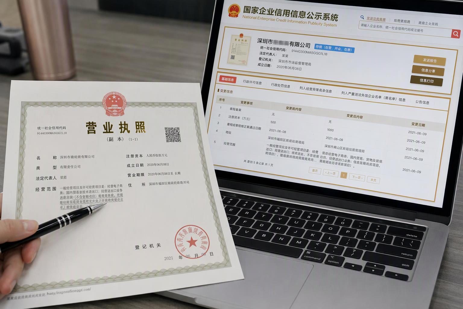 Chinese business license and credit registry lookup on a laptop compared against the draft contract